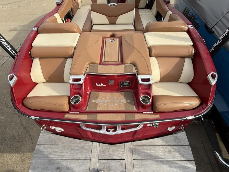Slide: The Image of 2016 MasterCraft X23 boat with tan and red seating, rear view. - 24