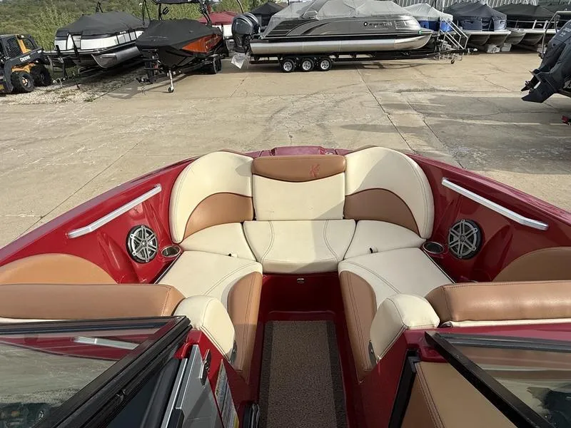 Slide: The Image of 2016 MasterCraft X23 boat interior with red and beige seating, parked in a marina. - 26