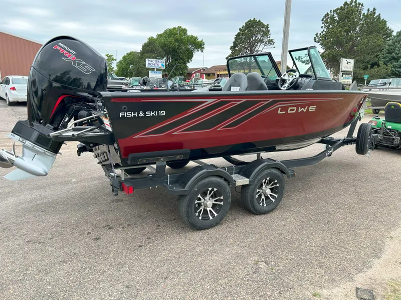 Slide: The Image of 2022 Lowe Fish & Ski 19 boat on trailer, red and black design, parked outdoors. - 4