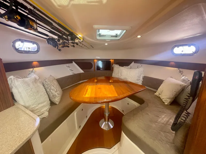 Slide: The Image of 2015 Pursuit 345 Offshore cabin with cozy seating and fishing rods. - 12