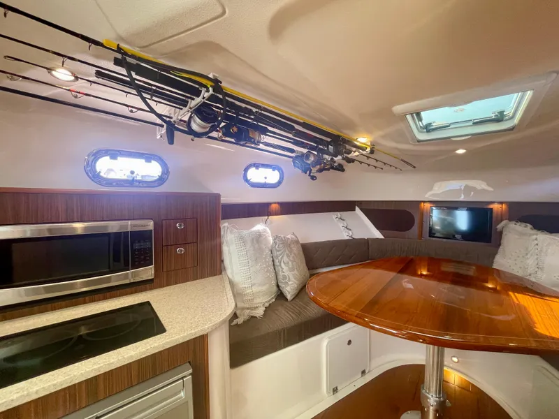 Slide: The Image of Interior of 2015 Pursuit 345 Offshore boat with kitchen and seating area. - 14