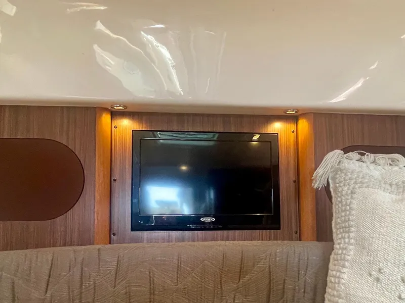 Slide: The Image of Interior of 2015 Pursuit 345 Offshore boat with mounted TV and cozy seating. - 15