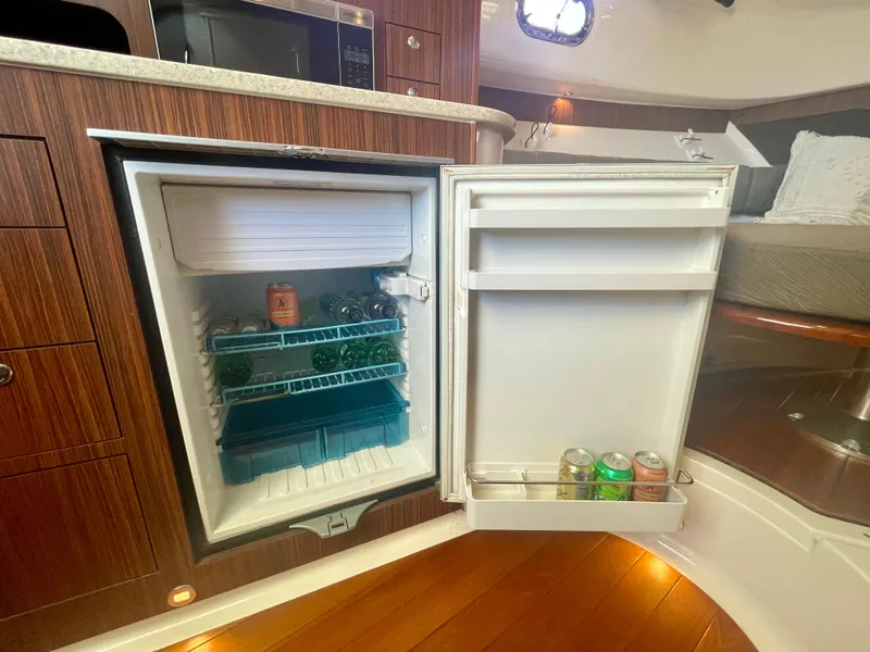 Slide: The Image of Open fridge in 2015 Pursuit 345 Offshore boat interior, stocked with drinks. - 19