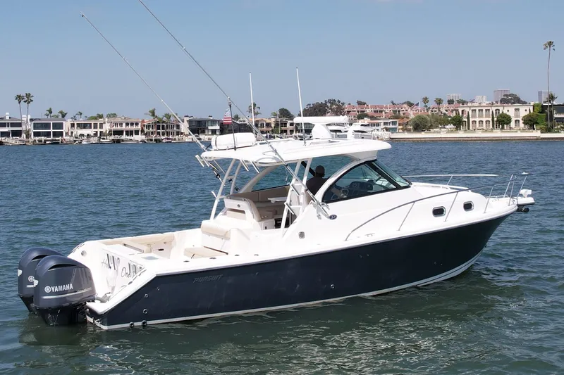 Slide: The Image of 2015 Pursuit 345 Offshore boat on water with Yamaha engines, coastal background. - 2