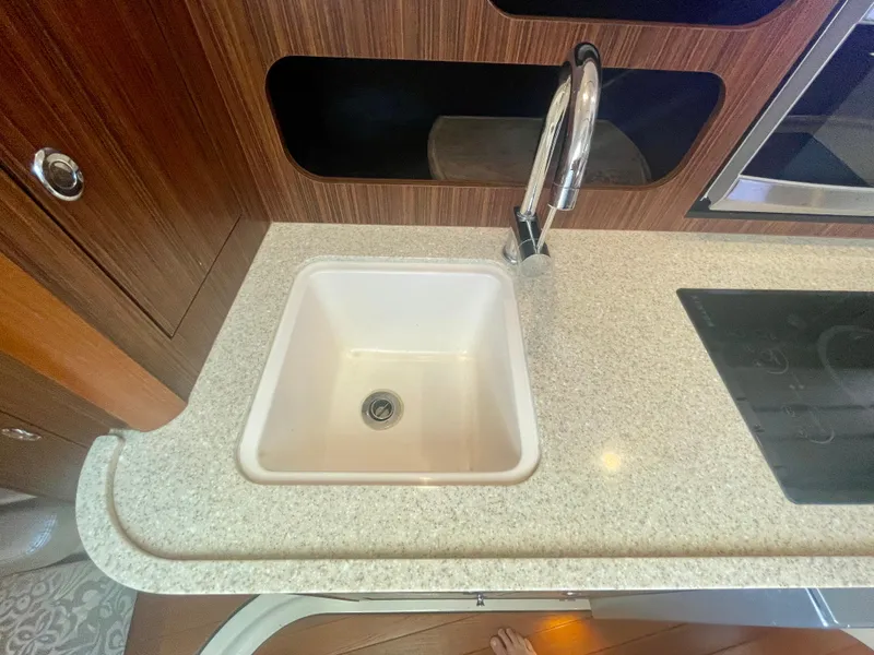 Slide: The Image of 2015 Pursuit 345 Offshore kitchen sink with modern faucet and countertop. - 22