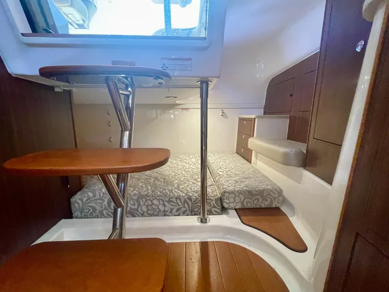 Slide: The Image of 2015 Pursuit 345 Offshore cabin interior with wooden steps and patterned bedding. - 24