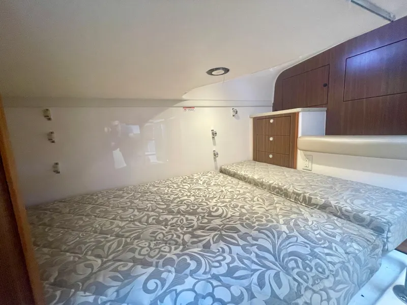 Slide: The Image of 2015 Pursuit 345 Offshore cabin interior with patterned bedding and wooden storage cabinets. - 25