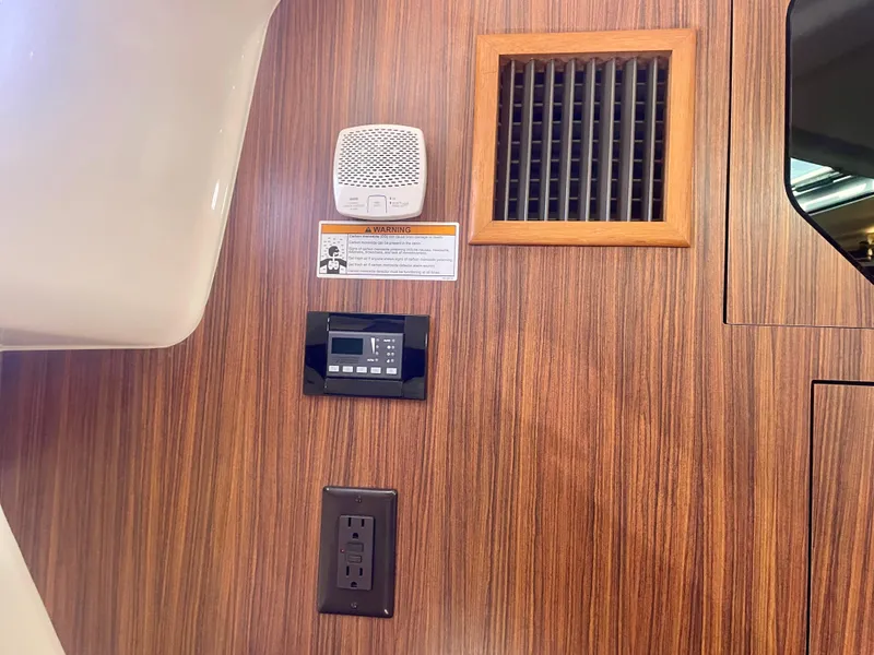 Slide: The Image of Interior of 2015 Pursuit 345 Offshore boat with wood paneling and electrical outlets. - 27