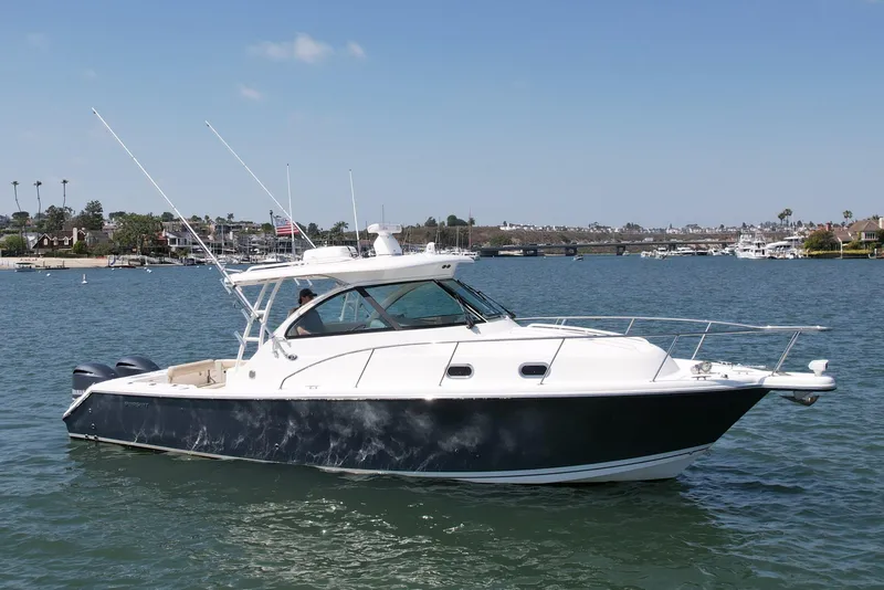 Slide: The Image of 2015 Pursuit 345 Offshore boat on calm water, clear sky, coastal background. - 3
