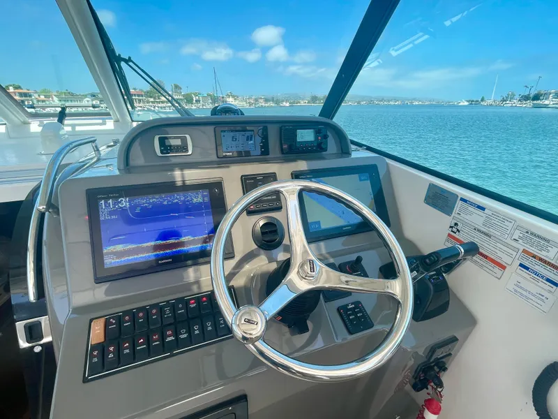 Slide: The Image of Helm of 2015 Pursuit 345 Offshore boat with navigation screens and steering wheel. - 36