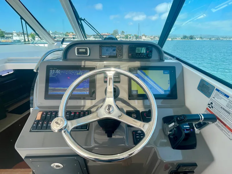 Slide: The Image of Helm of 2015 Pursuit 345 Offshore boat with navigation screens and controls. - 37