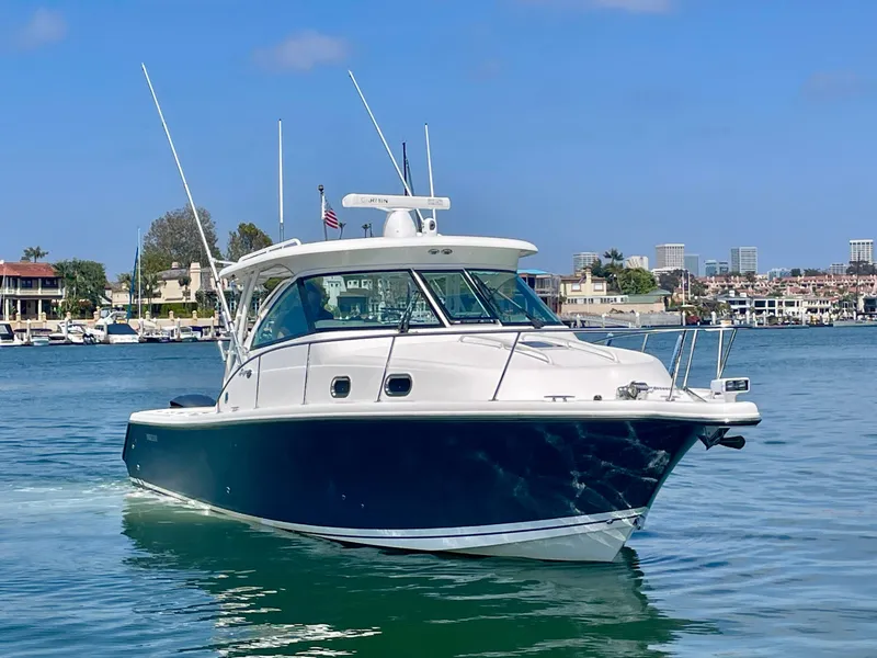 Slide: The Image of 2015 Pursuit 345 Offshore boat cruising in a scenic harbor setting. - 4