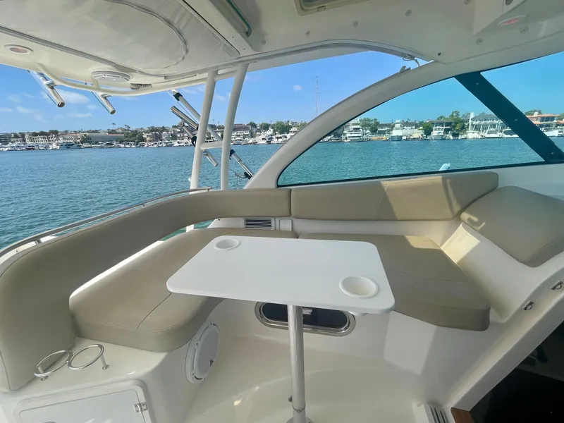 Slide: The Image of 2015 Pursuit 345 Offshore boat interior with seating and table, overlooking marina. - 42