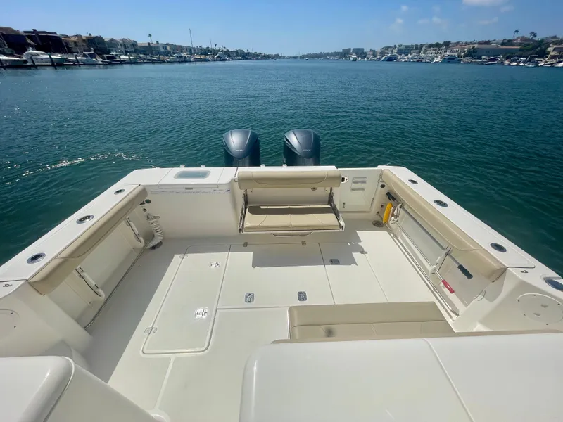 Slide: The Image of 2015 Pursuit 345 Offshore boat deck with twin engines, overlooking calm waters. - 43