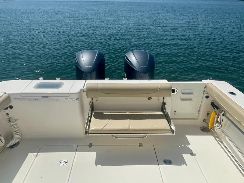 Slide: The Image of 2015 Pursuit 345 Offshore boat with dual engines and seating, on calm water. - 44