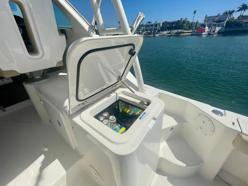 Slide: The Image of 2015 Pursuit 345 Offshore boat with open cooler, docked by the water. - 45