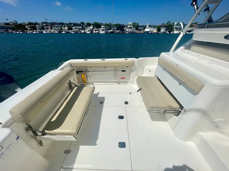 Slide: The Image of 2015 Pursuit 345 Offshore boat with spacious seating, docked by a marina. - 46