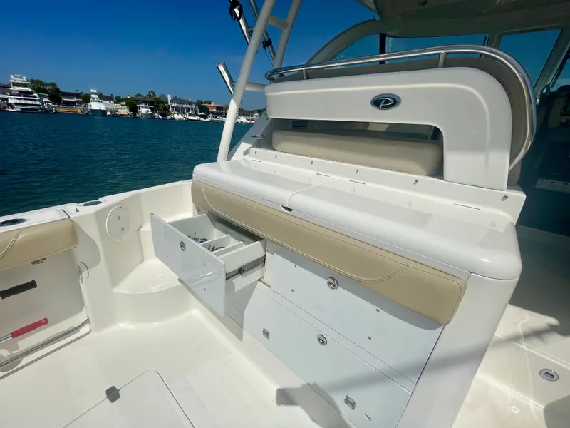 Slide: The Image of 2015 Pursuit 345 Offshore boat interior with storage drawers, docked by the water. - 47