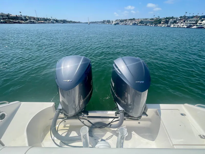 Slide: The Image of 2015 Pursuit 345 Offshore boat with dual outboard engines on a sunny day. - 49