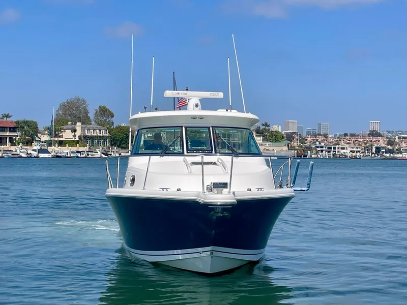 Slide: The Image of 2015 Pursuit 345 Offshore boat on calm water with cityscape background. - 5