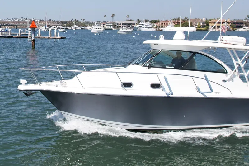 Slide: The Image of 2015 Pursuit 345 Offshore boat cruising on a sunny day in a marina. - 8