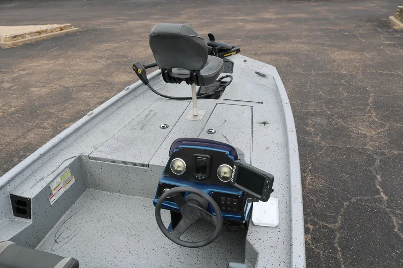 Slide: The Image of 2016 Xpress XP7 boat interior with steering wheel and seating on a paved surface. - 9