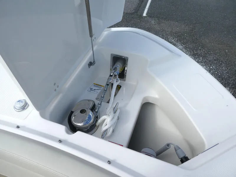 Slide: The Image of 2025 Boston Whaler 240 Vantage anchor storage compartment with winch and rope. - 14
