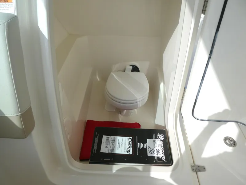 Slide: The Image of 2025 Boston Whaler 240 Vantage boat interior with compact marine toilet. - 16