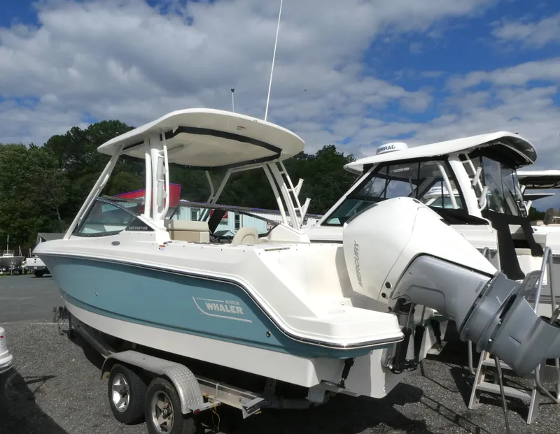 Slide: The Image of 2025 Boston Whaler 240 Vantage boat on trailer under blue sky. - 2
