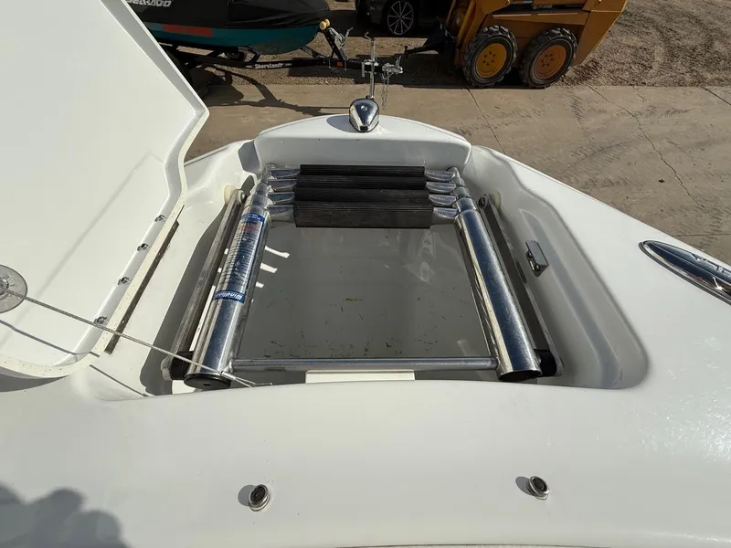 Slide: The Image of Open storage compartment on a 2009 Formula 240 Bowrider boat, showing metal components. - 10