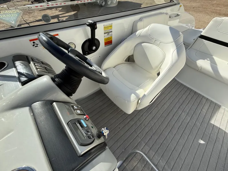 Slide: The Image of 2009 Formula 240 Bowrider cockpit with white seating and steering wheel. - 16