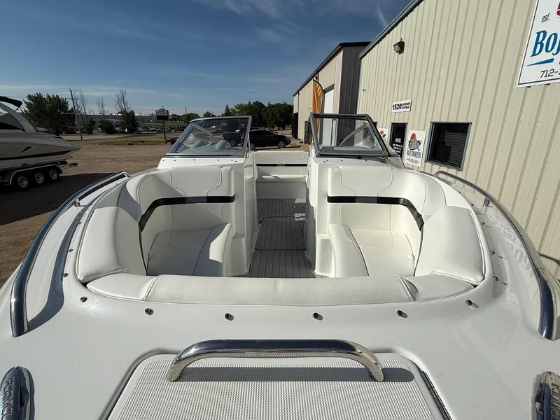 Slide: The Image of 2009 Formula 240 Bowrider boat with white seating, docked near a building. - 3