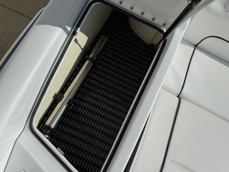 Slide: The Image of Open storage compartment in 2009 Formula 240 Bowrider boat, featuring a black mat and metal cylinder. - 33