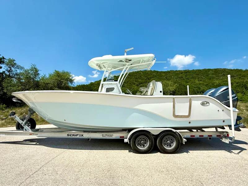 Slide: The Image of 2017 Sea Fox 288 Commander boat on trailer, parked outdoors under clear blue sky. - 11