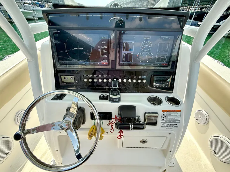 Slide: The Image of Control panel of a 2017 Sea Fox 288 Commander boat with steering wheel and navigation screens. - 48