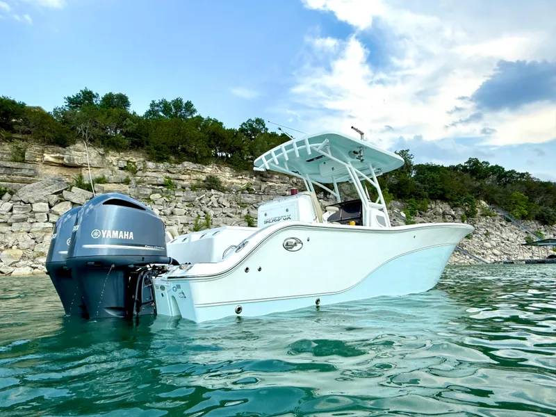 Slide: The Image of 2017 Sea Fox 288 Commander boat on water with Yamaha engine, rocky shoreline background. - 5