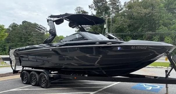 Slide: The Image of 2019 Centurion Fi 25 boat on trailer, sleek black design, parked outdoors. - 3
