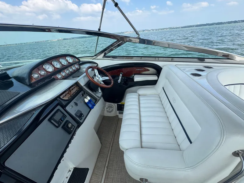 Slide: The Image of Interior of a 2005 Cobalt 360 boat with white seating and dashboard, overlooking the water. - 12
