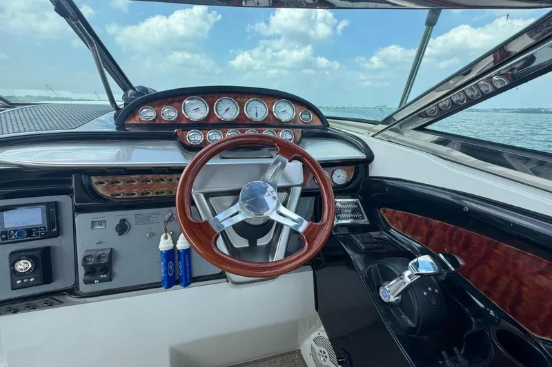 Slide: The Image of Dashboard of a 2005 Cobalt 360 boat with wooden steering wheel and gauges. - 13