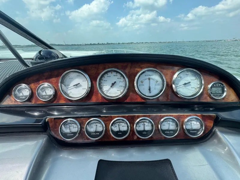 Slide: The Image of Dashboard of a 2005 Cobalt 360 boat with gauges, overlooking the water. - 15