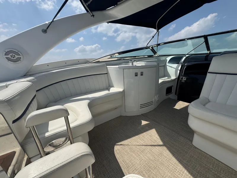 Slide: The Image of Luxurious interior of a 2005 Cobalt 360 boat with white seating and blue canopy. - 21