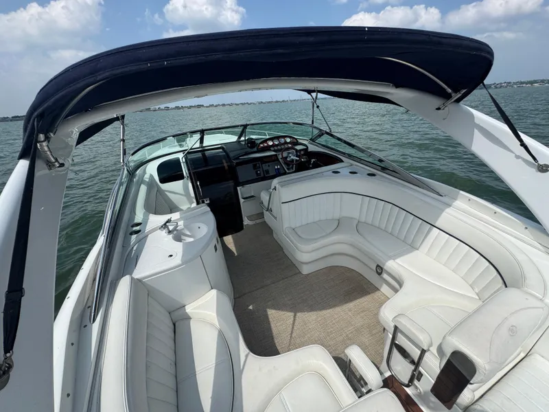 Slide: The Image of 2005 Cobalt 360 boat interior with white seating and canopy on open water. - 22