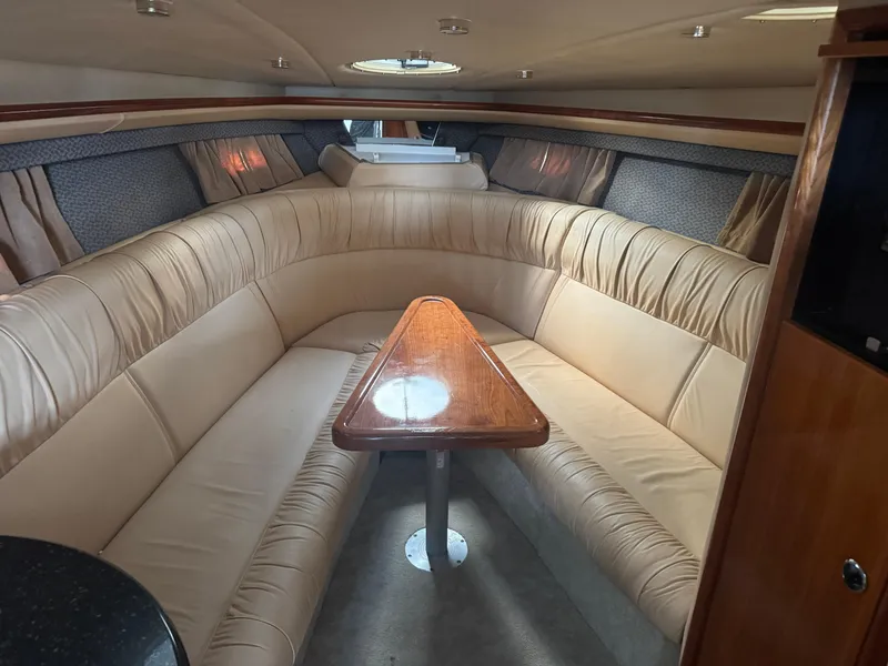 Slide: The Image of Interior of a 2005 Cobalt 360 boat with beige seating and wooden table. - 25