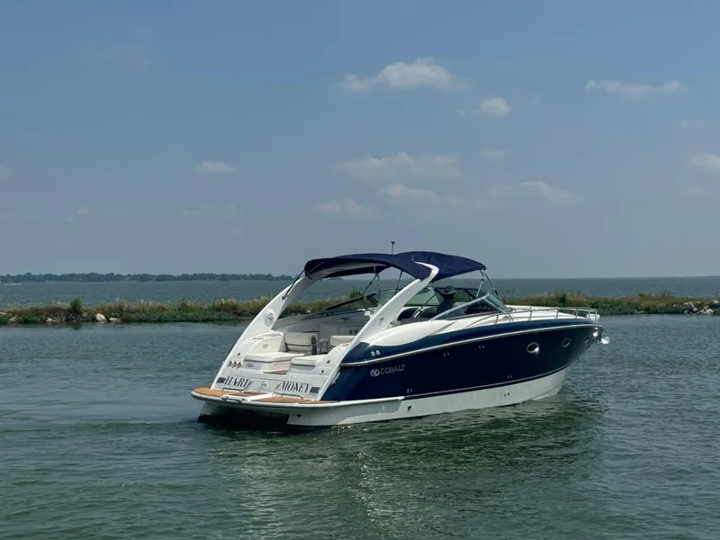Slide: The Image of 2005 Cobalt 360 boat cruising on a calm lake under a clear sky. - 4