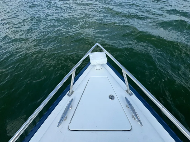 Slide: The Image of Bow of 2005 Cobalt 360 boat on water, showcasing sleek design and railing. - 8