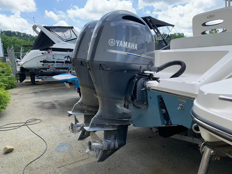 Slide: The Image of 2021 Cobia 240 CC with Yamaha outboard motors, parked outdoors. - 10