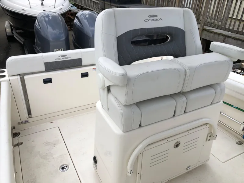 Slide: The Image of 2021 Cobia 240 CC boat interior with dual engines and cushioned seating. - 2