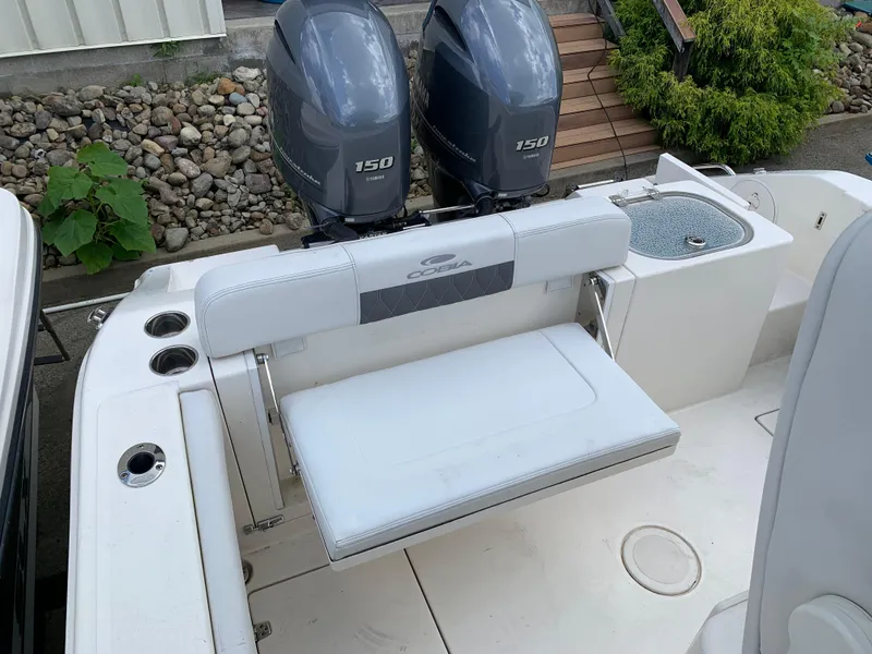 Slide: The Image of 2021 Cobia 240 CC boat with dual Yamaha 150 engines and seating area. - 7