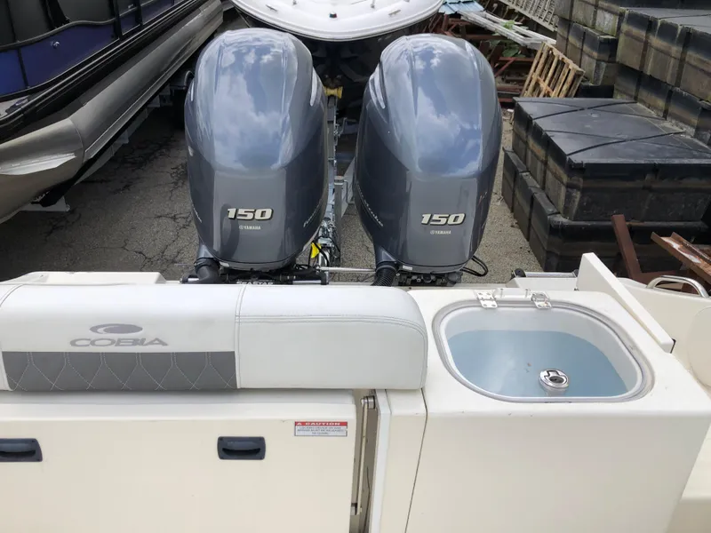 Slide: The Image of 2021 Cobia 240 CC boat with dual 150 horsepower engines and onboard sink. - 8
