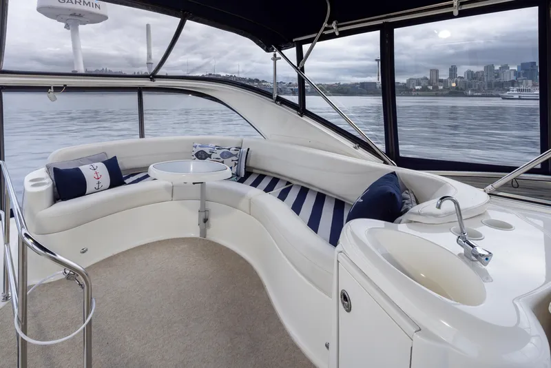 Slide: The Image of 2008 Meridian 391 Sedan interior with curved seating, table, and sink, overlooking waterfront cityscape. - 14